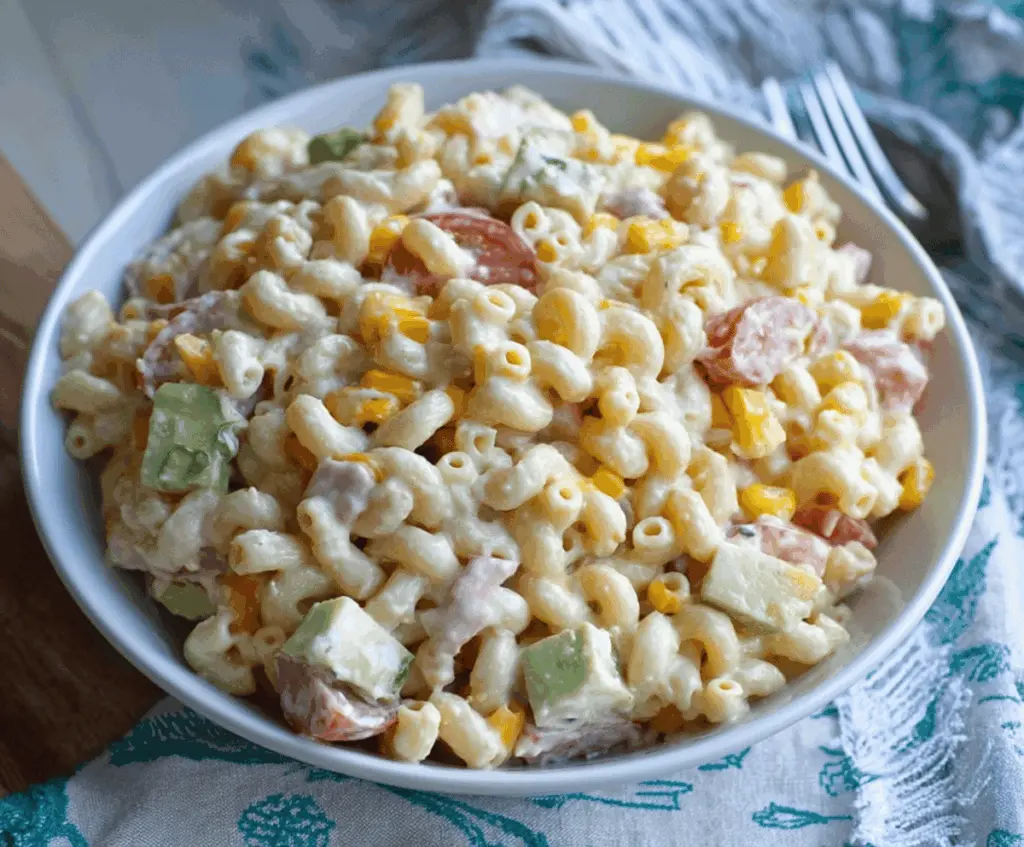 Colorful Mexican Macaroni Salad with fresh vegetables and herbs in a white bowl